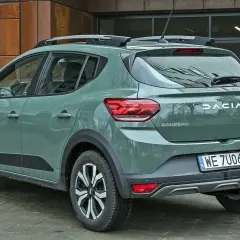 Dacia Sandero w zielonym kolorze lakieru, z relingami dachowymi, prezentuje się nowocześnie.