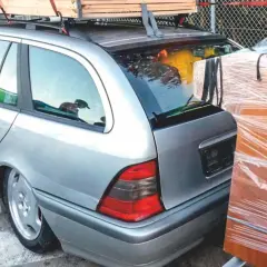 Srebrne kombi z bagażem na dachu i meblami obok. Jak obliczyć ładowność pojazdu, by bezpiecznie przewieźć wszystko?