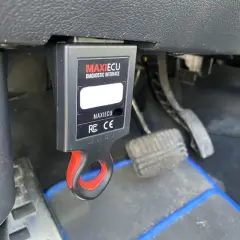 Interfejs diagnostyczny MaxiECU podłączony do portu OBD w Dacia Duster.