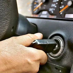 Dłoń przekręca kluczyk w stacyjce. Auto odpala i gaśnie, co frustruje kierowcę.