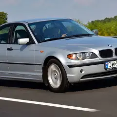 Srebrne BMW E46 330i jedzie po autostradzie, za kierownicą siedzi mężczyzna.