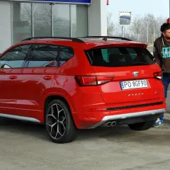 Mężczyzna tankuje czerwonego SUV-a. Zastanawiasz się, ile pali suv? Ten model Seat Ateca właśnie dostaje paliwo.