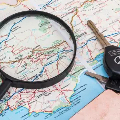 Planowanie trasy z ViaMichelin: lupa nad mapą, kluczyki samochodowe i brelok.