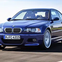 Niebieskie BMW M3 E46, ikona motoryzacji z lat produkcji 2000-2006, pędzi po drodze.