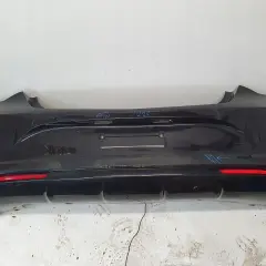 Ciemny zderzak tylny Opel Astra J z czujnikami parkowania i odblaskami.