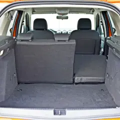 Pusty bagażnik Dacia Duster z opuszczonymi siedzeniami, gotowy na podróż.