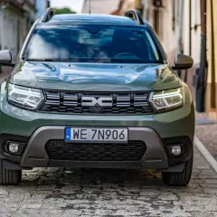 Zielony Dacia Duster na brukowanej uliczce. Sprawdź, jakie jest dacia duster spalanie i wybierz się na przygodę.