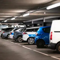 Rząd samochodów na parkingu podziemnym, gdzie czujnik parkowania do garażu ułatwia manewrowanie.