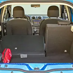 Bagażnik Dacia Sandero, gotowy na podróż. Widoczna apteczka i torba.