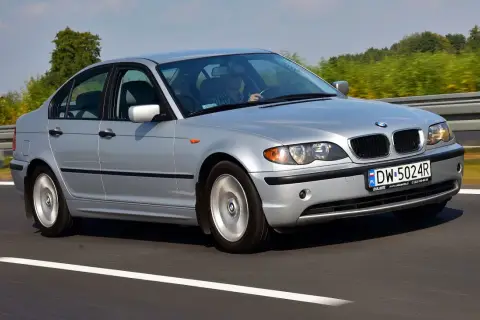 Srebrne BMW E46 330i jedzie po autostradzie, za kierownicą siedzi mężczyzna.