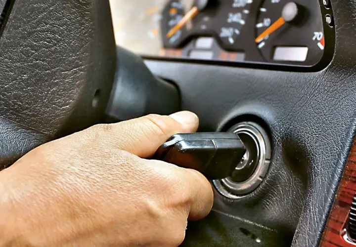 Dłoń przekręca kluczyk w stacyjce. Auto odpala i gaśnie, co frustruje kierowcę.