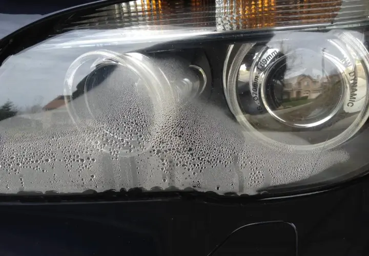 Krople wody wewnątrz reflektora samochodowego, wskazujące na potrzebę klejenia.