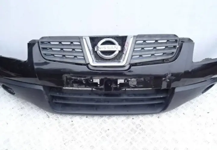 Czarny zderzak Nissan Qashqai z charakterystycznym grillem i logo marki.