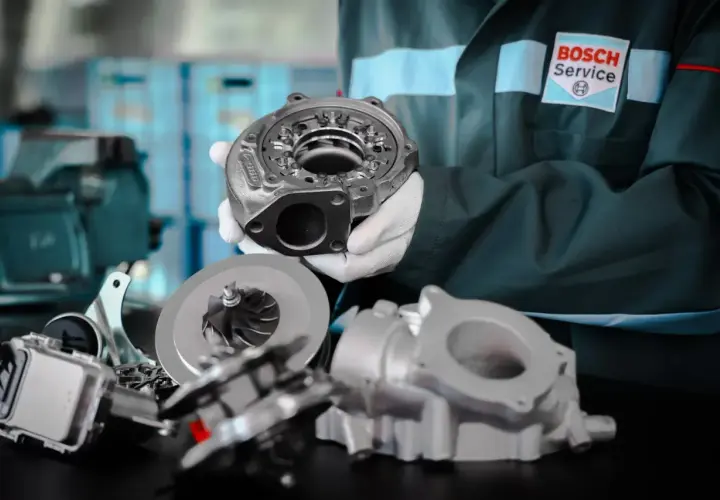 Mechanik w białych rękawiczkach prezentuje turbosprężarkę. Dbałość o detale zapobiega wibracjom podczas przyspieszania.