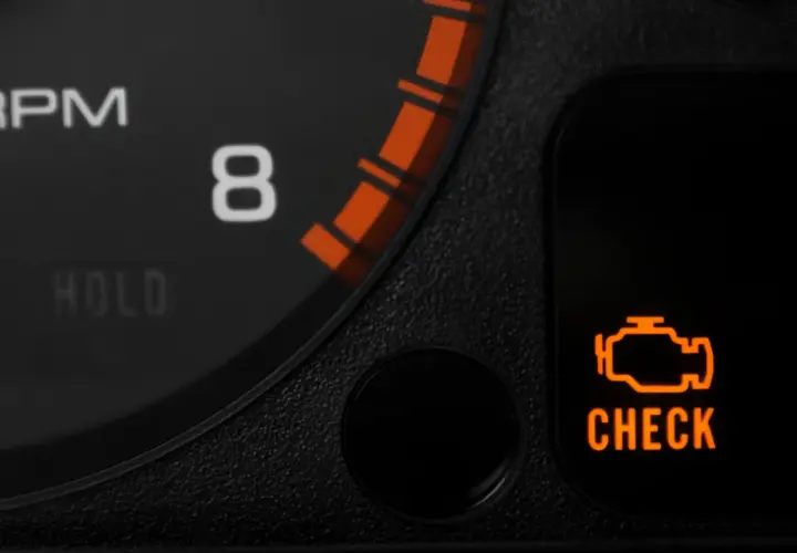 Pomarańczowa kontrolka "check engine" świeci się na desce rozdzielczej BMW, sygnalizując problem z silnikiem.