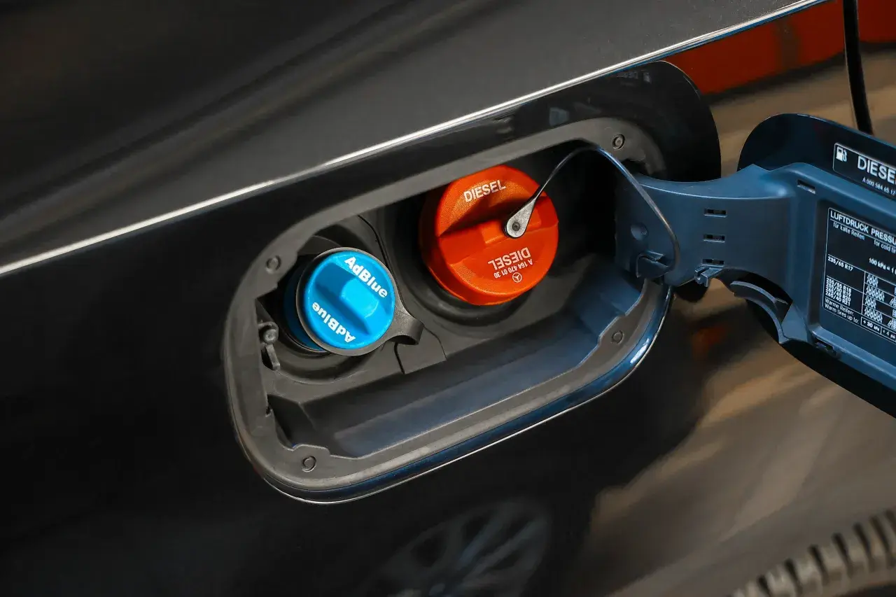 Niebieski korek AdBlue i pomarańczowy korek Diesel w klapce wlewu paliwa. W ten sposób sprawdzisz poziom AdBlue w swoim samochodzie.