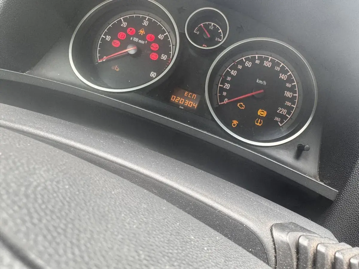Kontrolka samochód z kluczykiem Opel świeci się, wskazując problem z immobilizerem lub kluczykiem. Na desce rozdzielczej widoczne są też inne kontrolki.