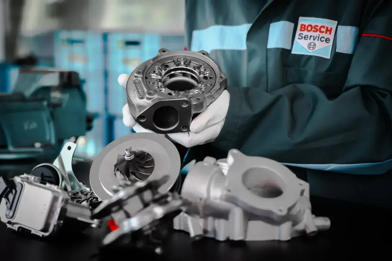 Mechanik w białych rękawiczkach prezentuje turbosprężarkę. Dbałość o detale zapobiega wibracjom podczas przyspieszania.