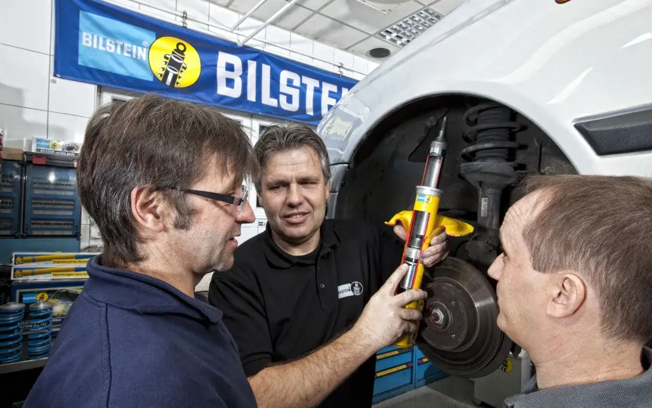 Mechanik pokazuje przekrój amortyzatora, prezentując zestaw naprawczy Bilstein.