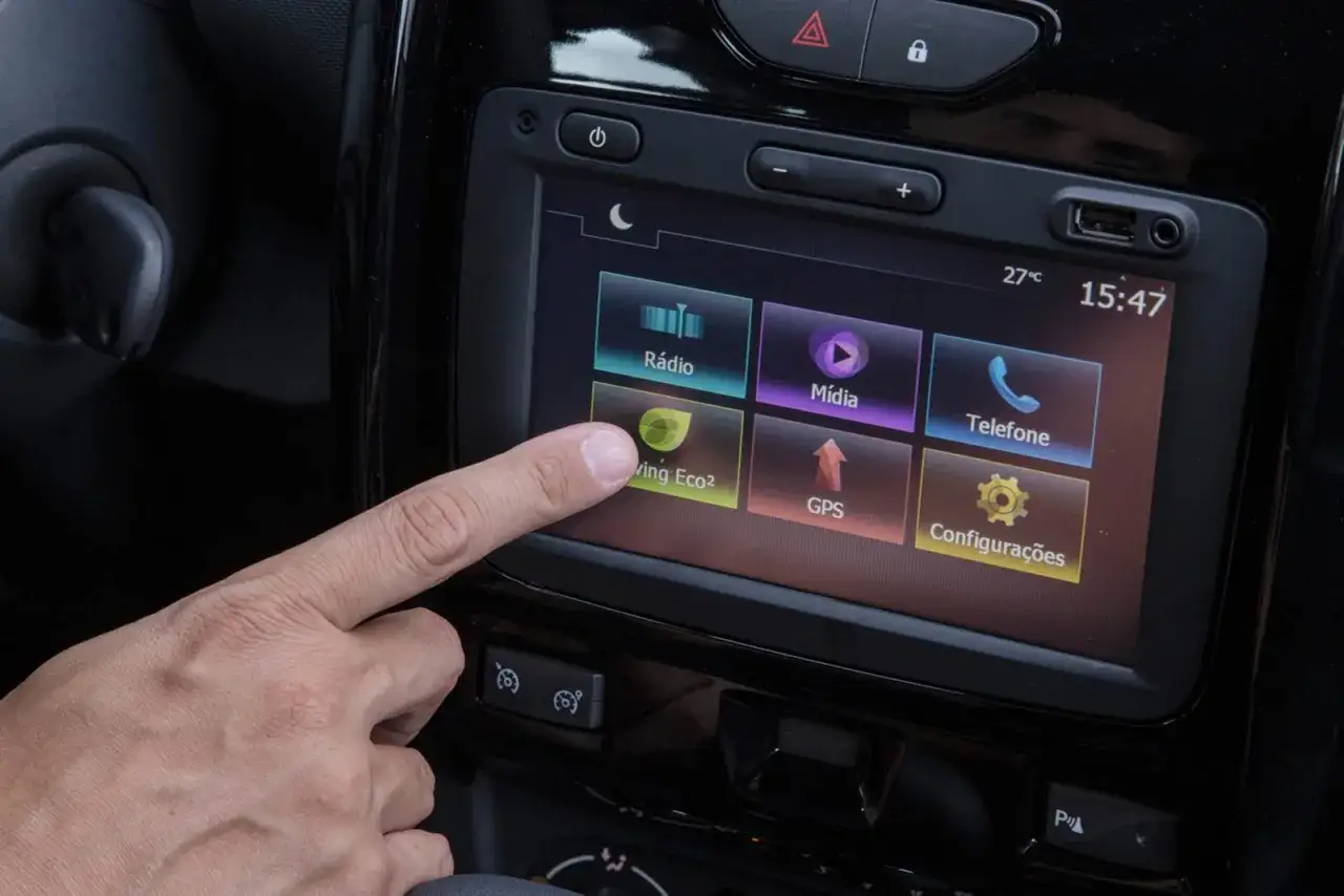 Dłoń dotyka ekranu multimedialnego z funkcjami jak radio, media, telefon, GPS. To medianav evolution android auto.