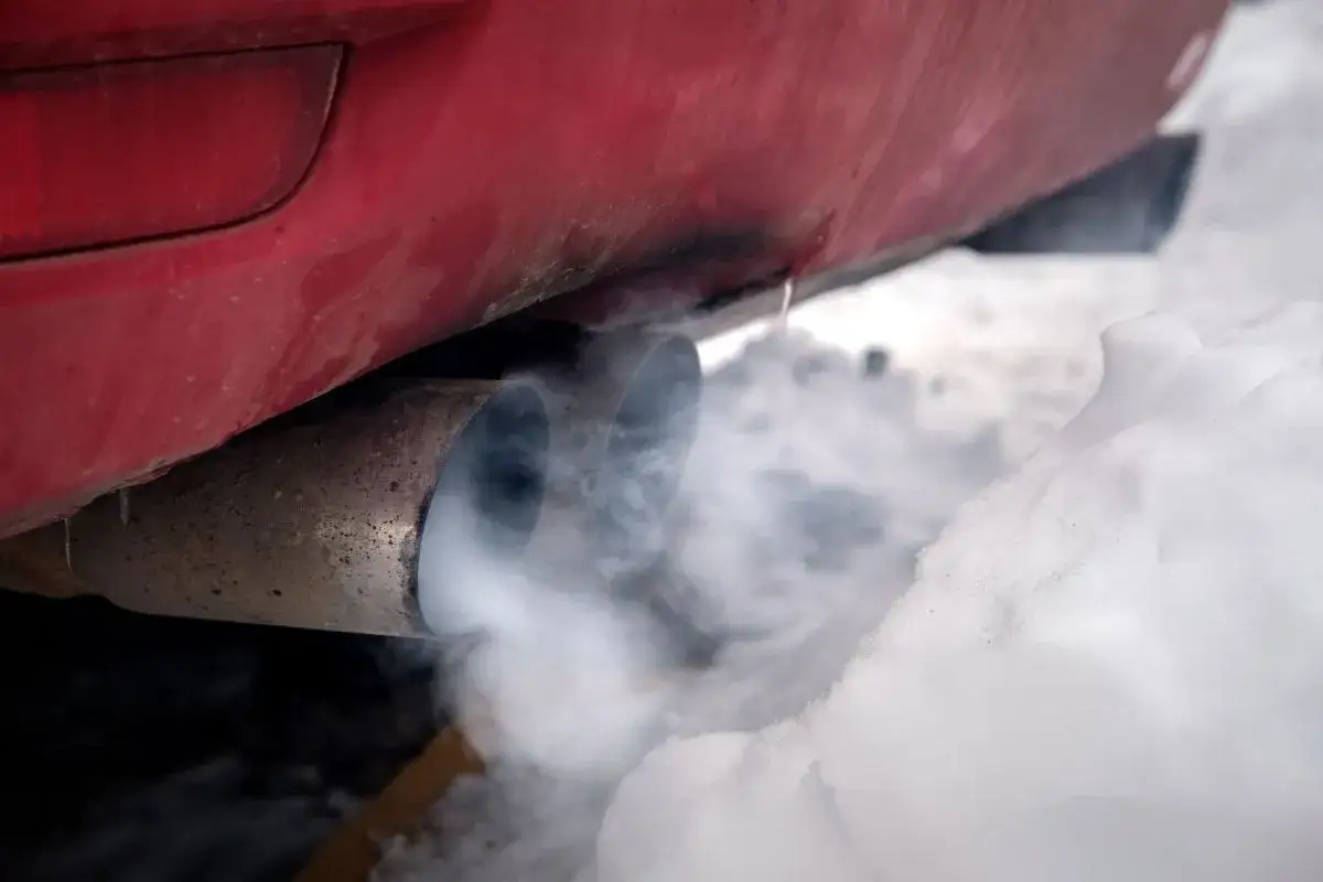 Zimne auto pluje wodą z wydechu, tworząc parę na tle śniegu.