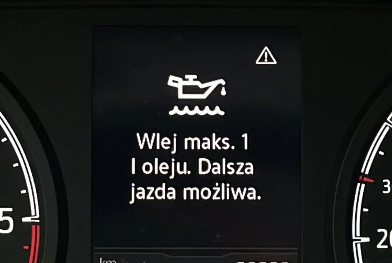 Pomarańczowa kontrolka oleju z ikoną silnika i tekstem