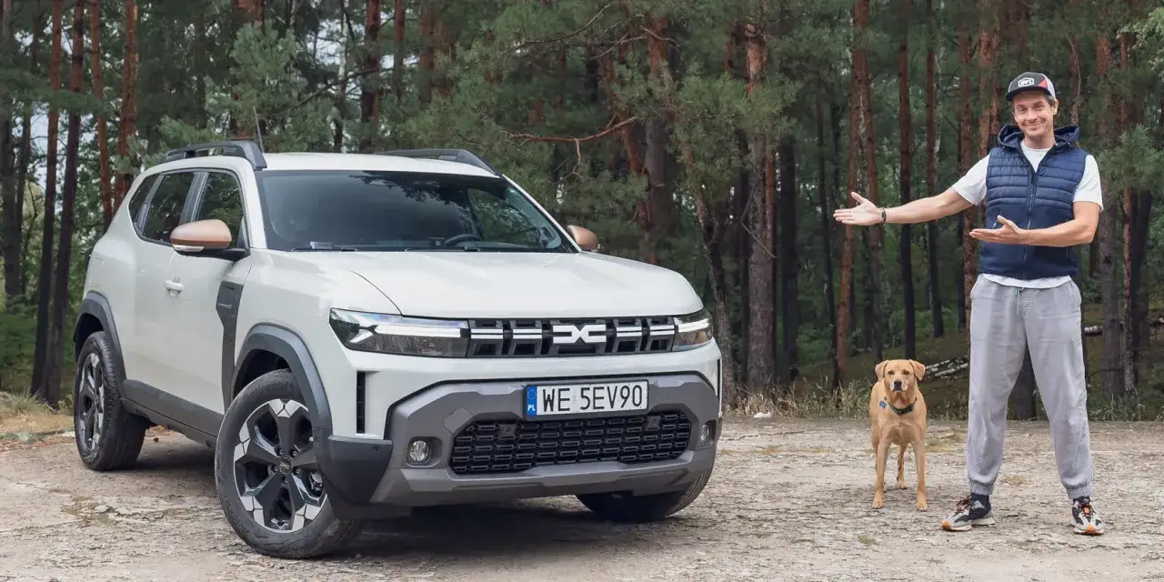 Mężczyzna z psem obok białego Dacia Duster, zastanawia się jaki silnik wybrać.