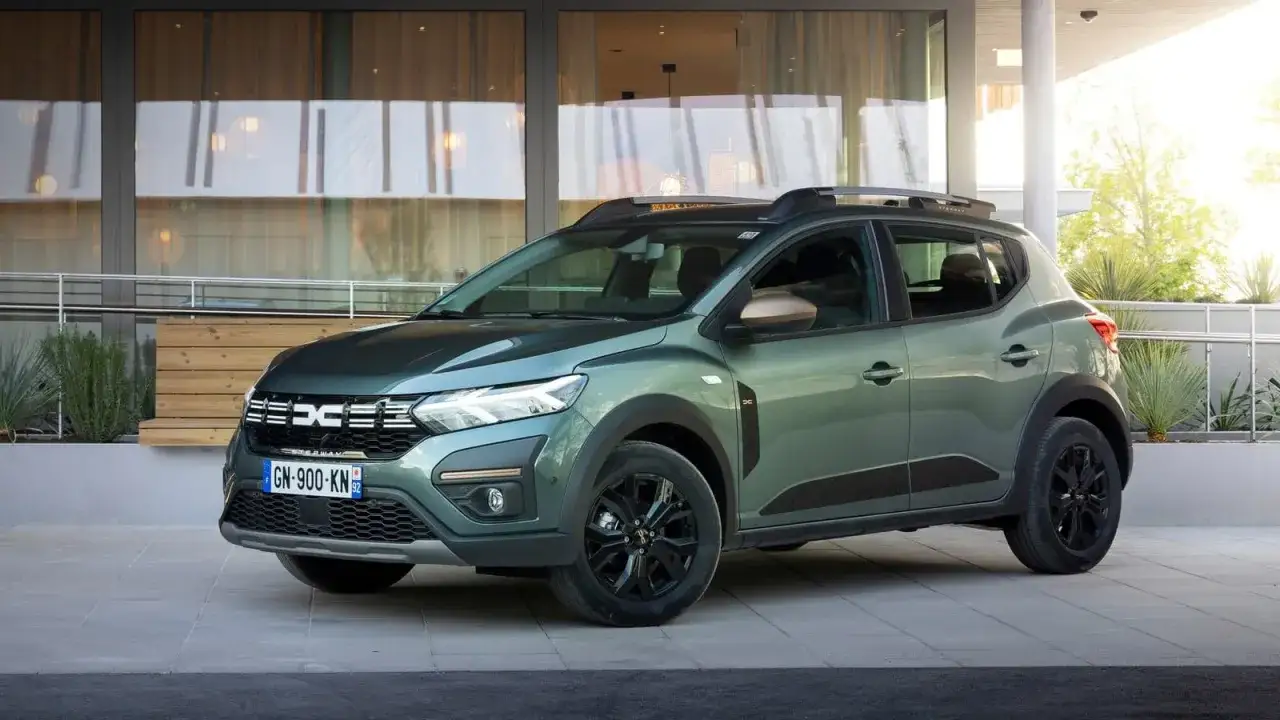 Dacia Sandero w zielonym kolorze lakieru, z czarnymi felgami i relingami, prezentuje się stylowo.
