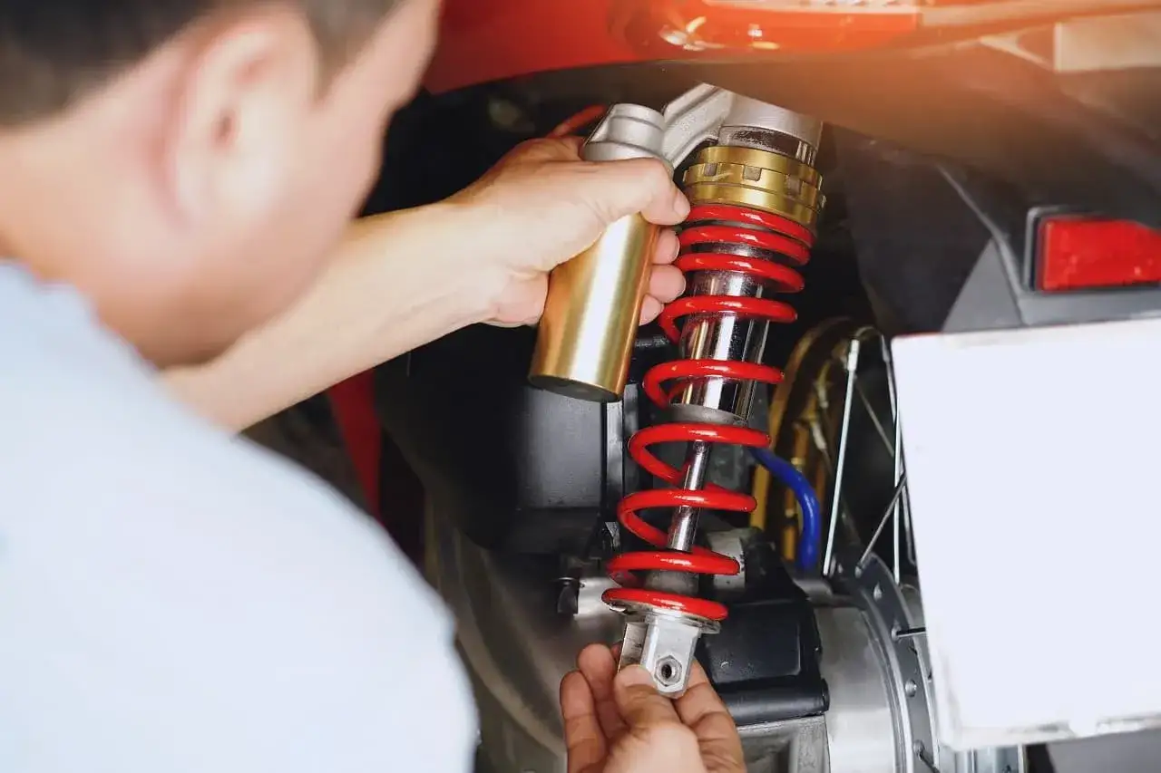 Mechanik montuje nowy zestaw naprawczy amortyzatora w motocyklu.