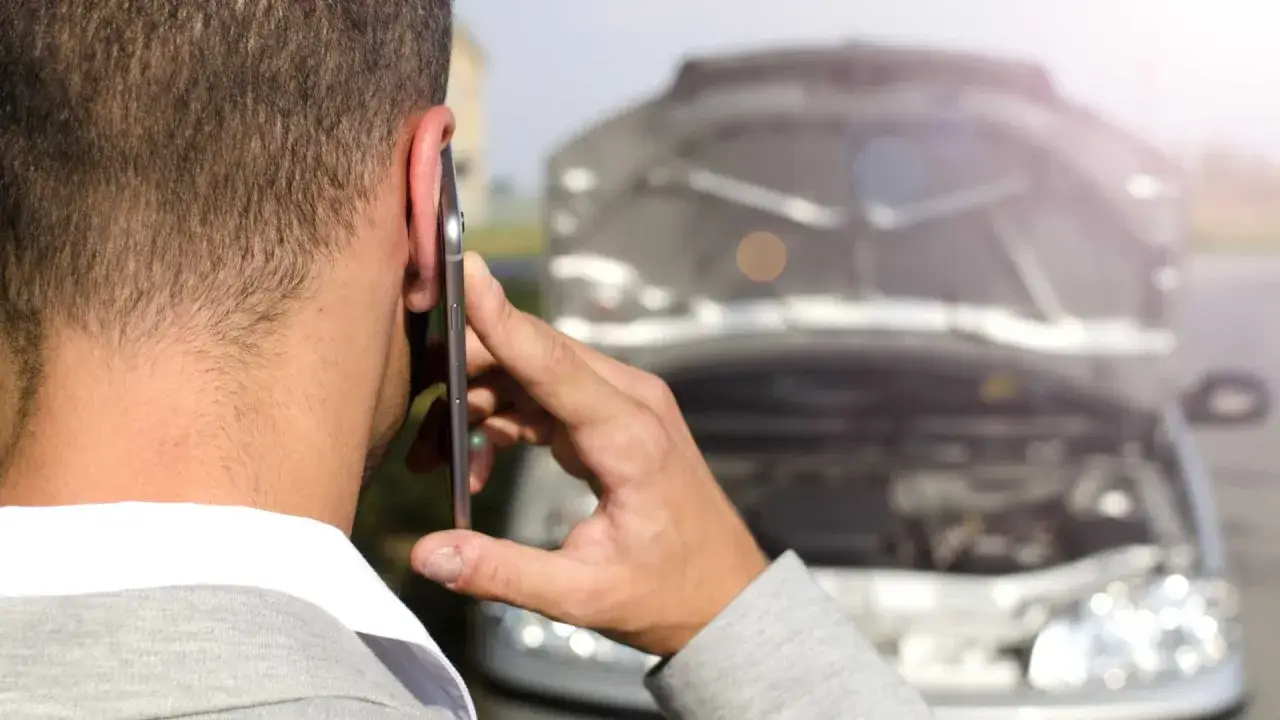 Mężczyzna dzwoni po pomoc drogową, bo silnik diesel zgasł podczas jazdy i nie odpala.