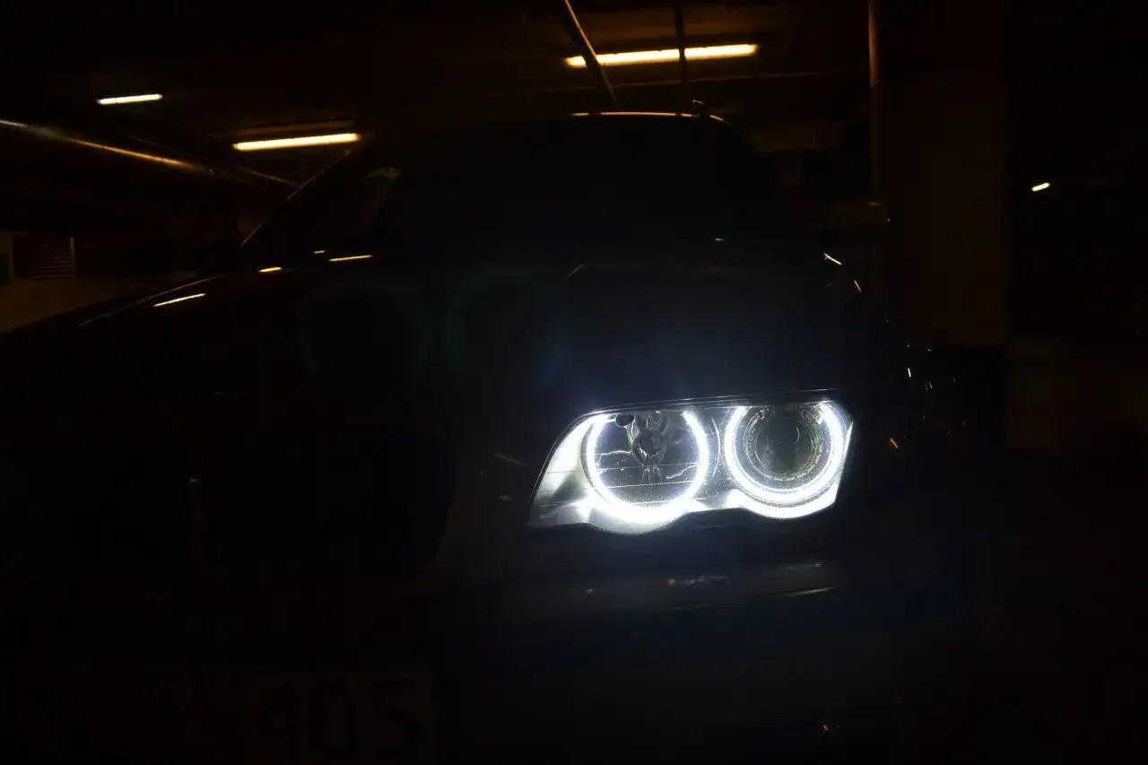 Jasne, oto opis alternatywny:
BMW E46 z zapalonymi ringami w ciemnym garażu.